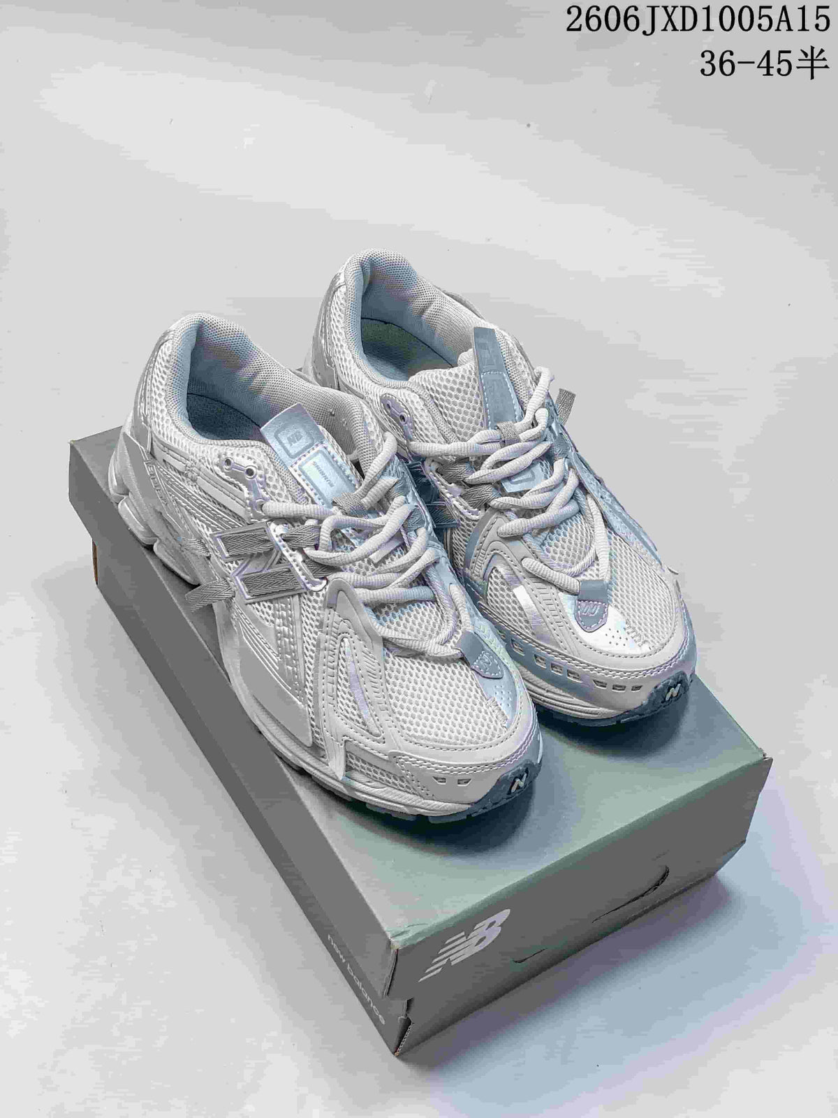 Pair of silver-grey New Balance 1906 sneakers shown from above on a shoebox