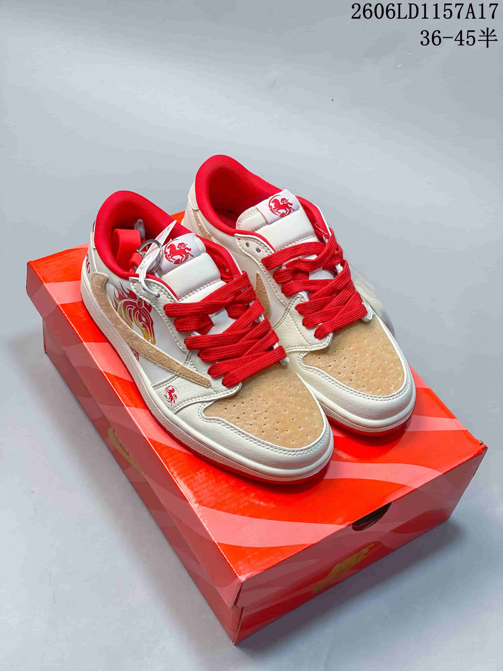 Pair of cream and red low-top sneakers shown on a red shoebox