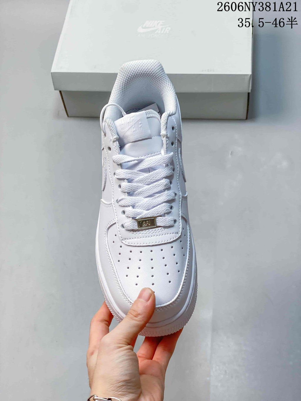 Front view of a white low-top sneaker with perforated toe and laces