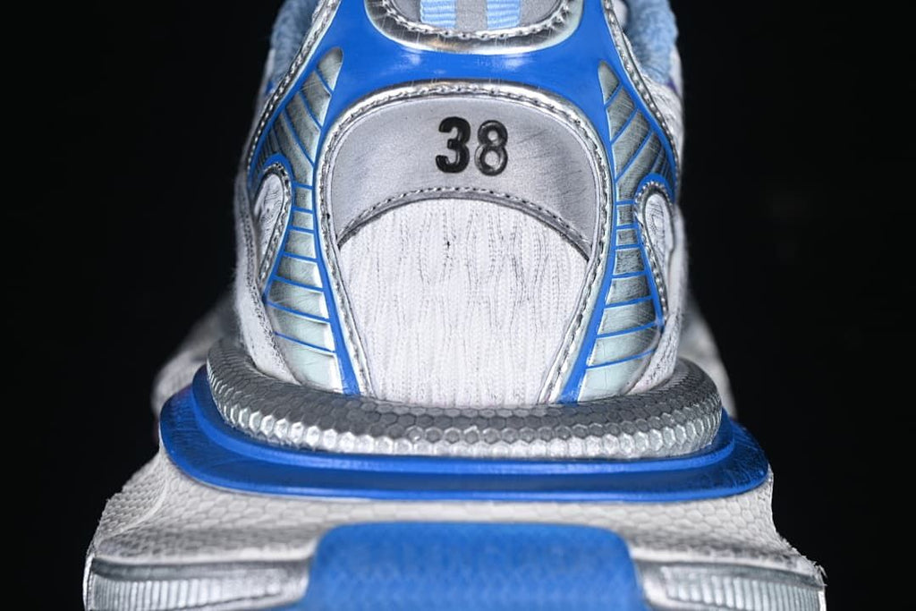 Rear view of the sneaker with blue trim and a size 38 marking