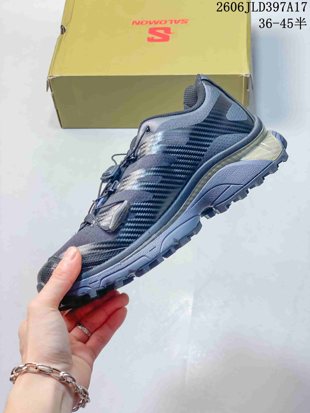 Side view of a dark Salomon XT-4 OG sneaker with a quick-lacing system
