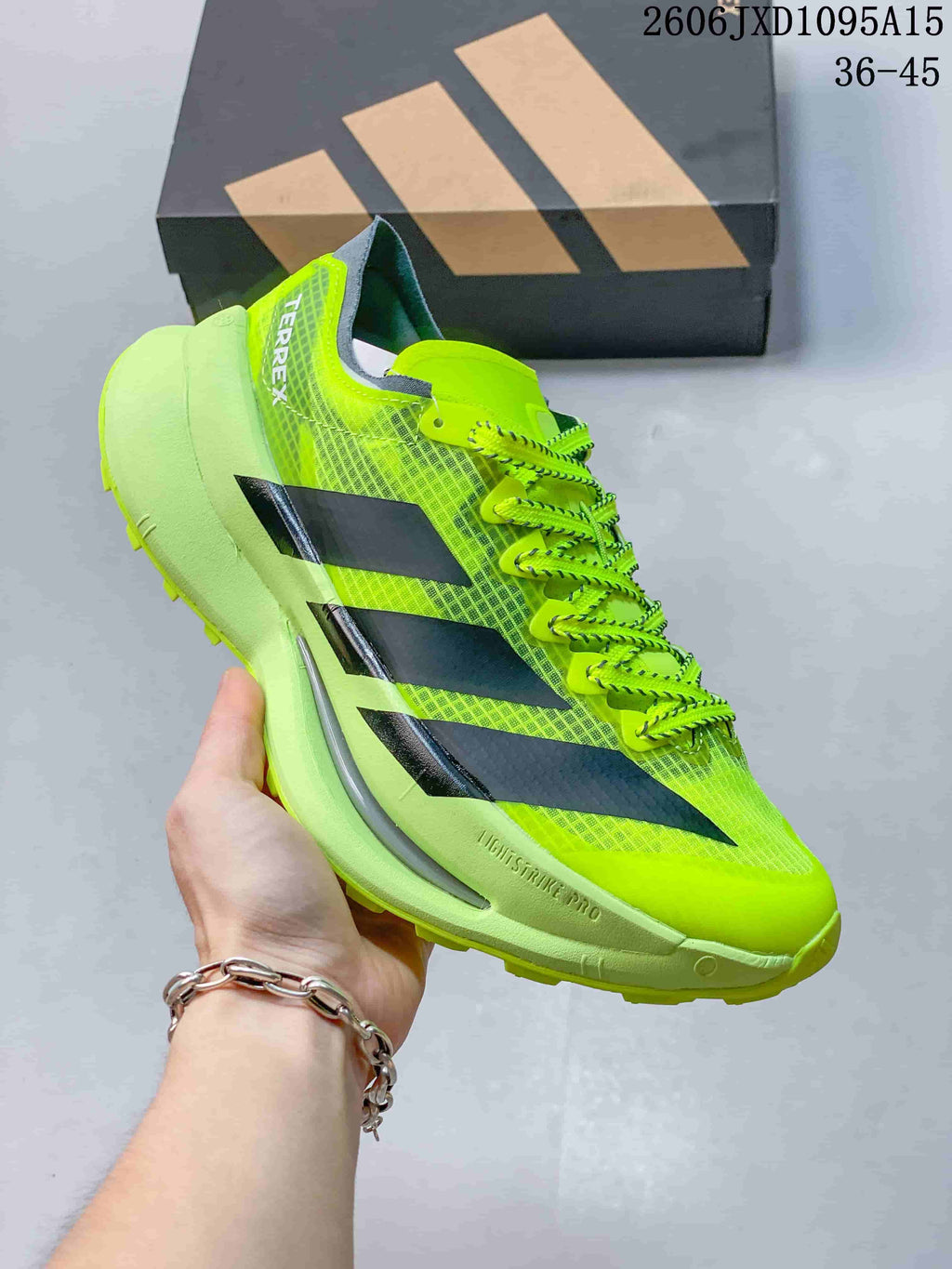 Side view of a neon yellow Adidas Terrex shoe with dark stripes