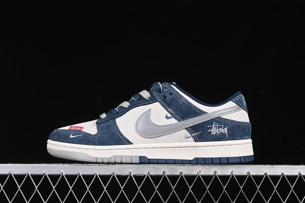 Side view of a navy, white, and gray low-top Dunk-style sneaker