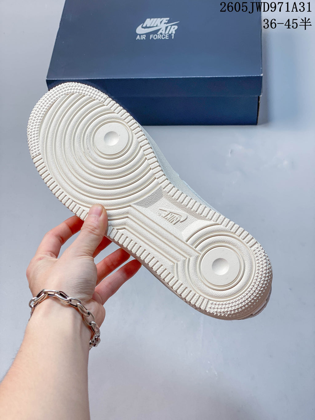 Close-up of the textured outsole on a white and beige low-top sneaker.