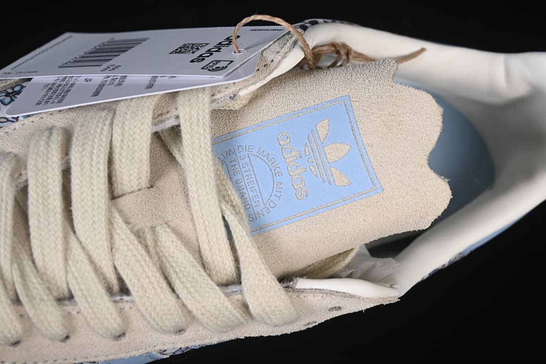 Close-up of cream laces and tongue label on the floral-print sneaker