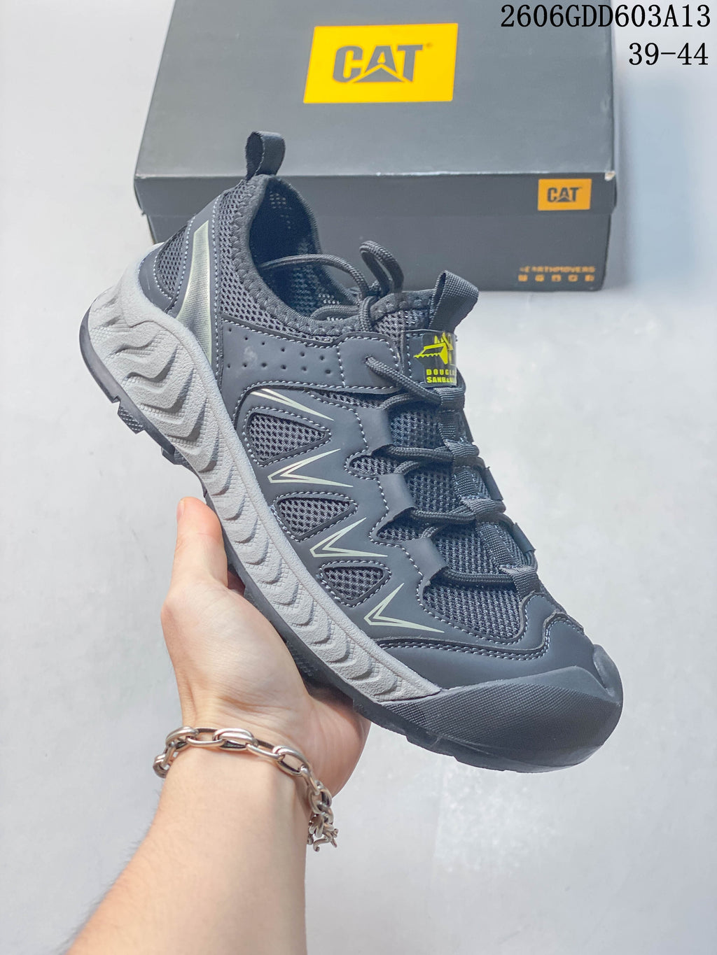 Angled side view of the dark gray sneaker with mesh sections and contrasting light-gray midsole