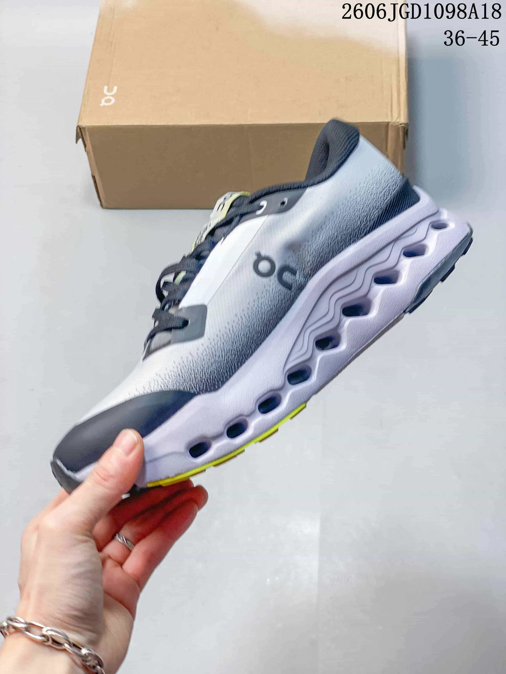 Side view of the shoe showing the sculpted sole and gray, navy and yellow colorway