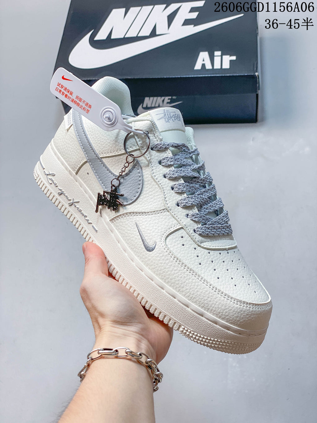 Angled view of the ivory and grey Nike Air Force 1 with decorative charm