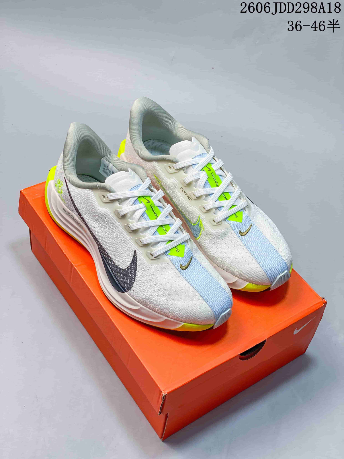 Pair of white Nike Pegasus Plus shoes with pale blue and bright yellow-green accents.