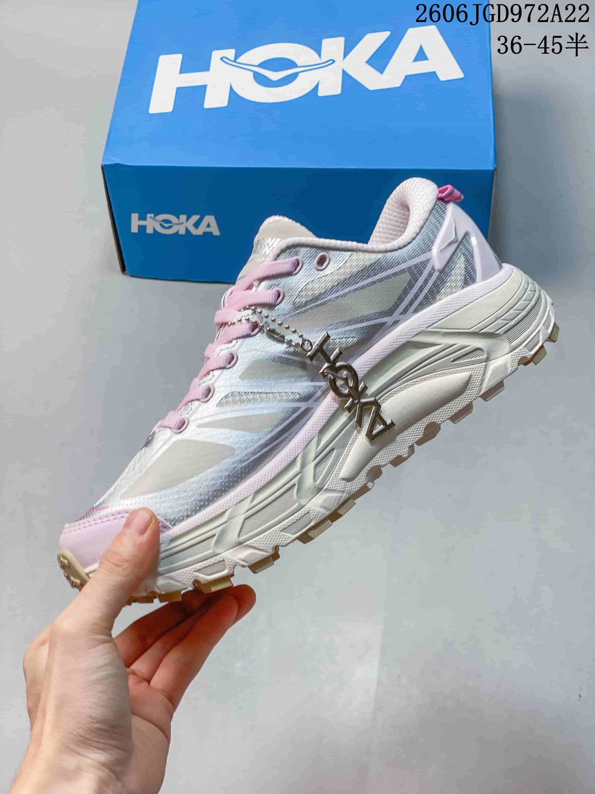 Side view of the silver-toned shoe with pink accents and a rugged outsole