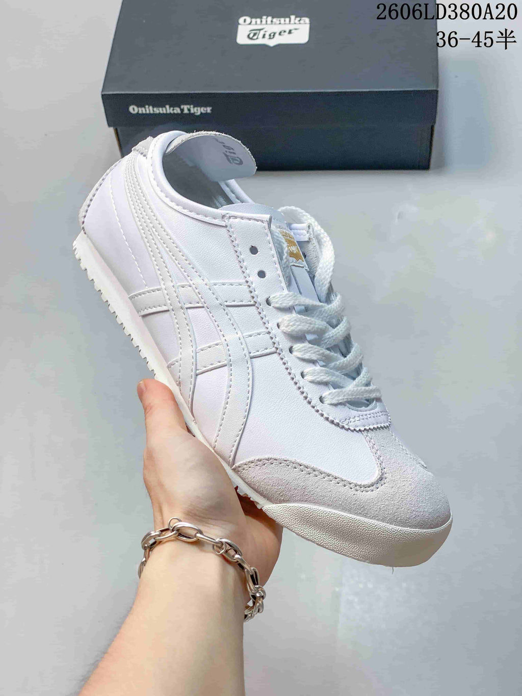 Angled side view of a white Onitsuka Tiger sneaker with gray toe accents