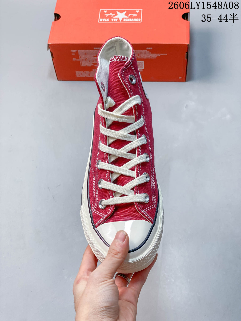 Front view of a red Converse high-top sneaker showing its laces and rubber toe cap.