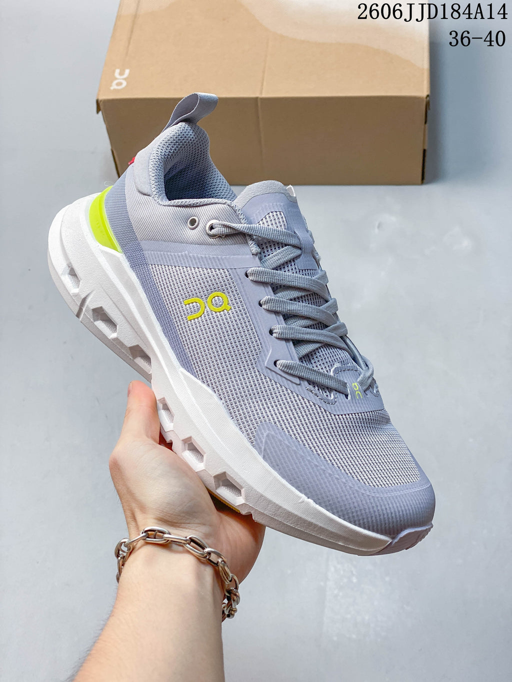 Angled side view of a grey On Cloudpulse Next shoe with yellow branding and a white sole.