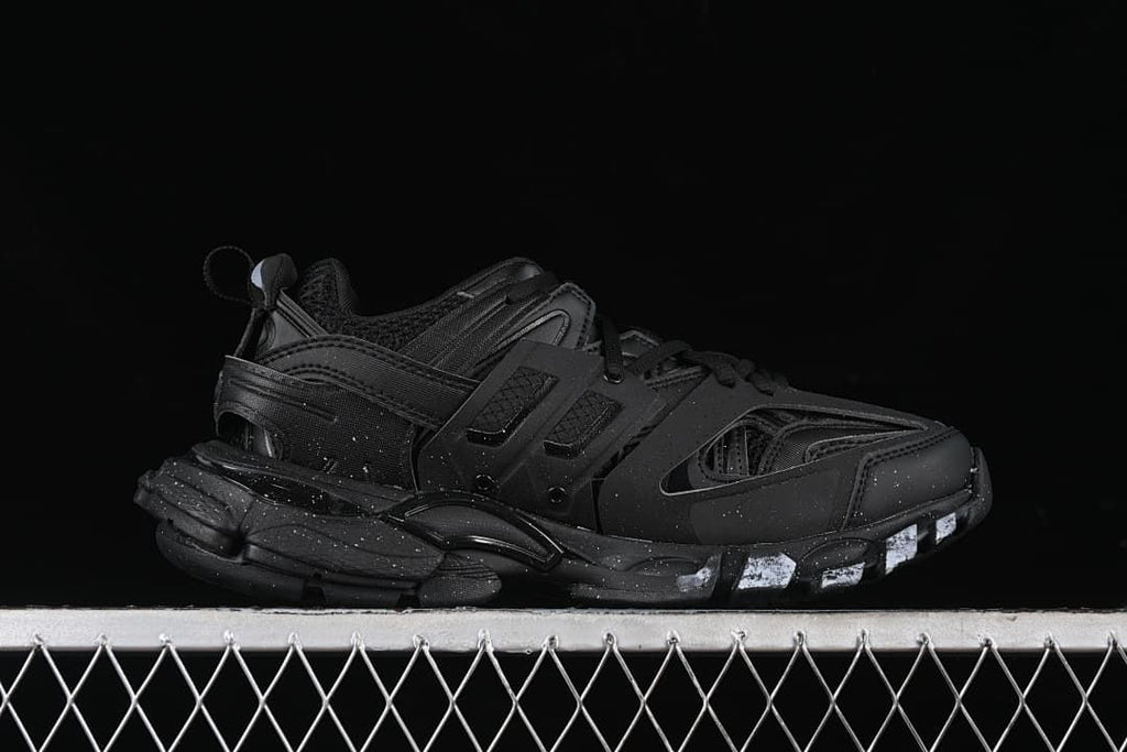 Side profile of the black sneaker with layered sole and white accents.