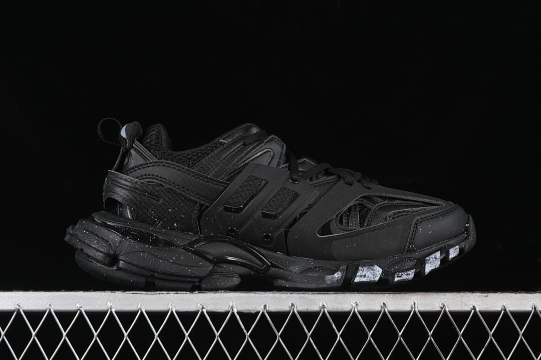 Side profile of the black sneaker with layered sole and white accents.