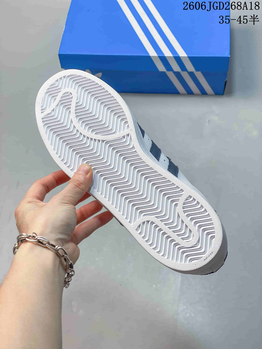 View of the white patterned outsole and tread on an Adidas Superstar sneaker.