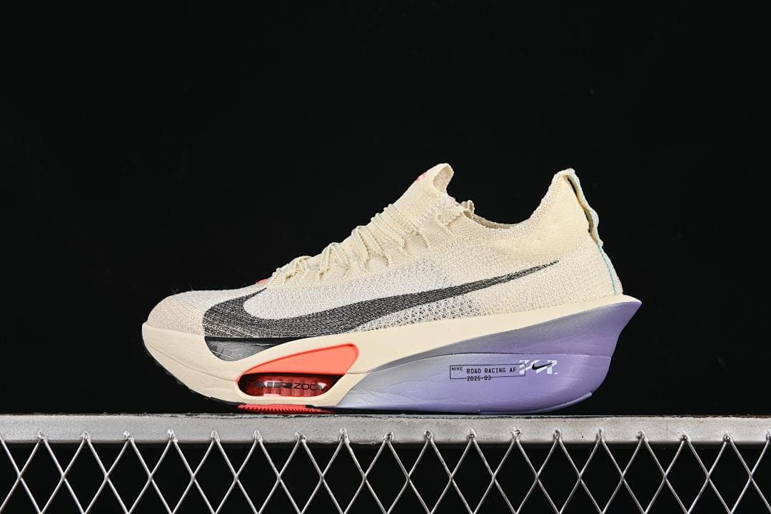 Side view of a cream Nike ZoomX Vaporfly Next% 3 shoe with black Swoosh, coral accent and purple heel section