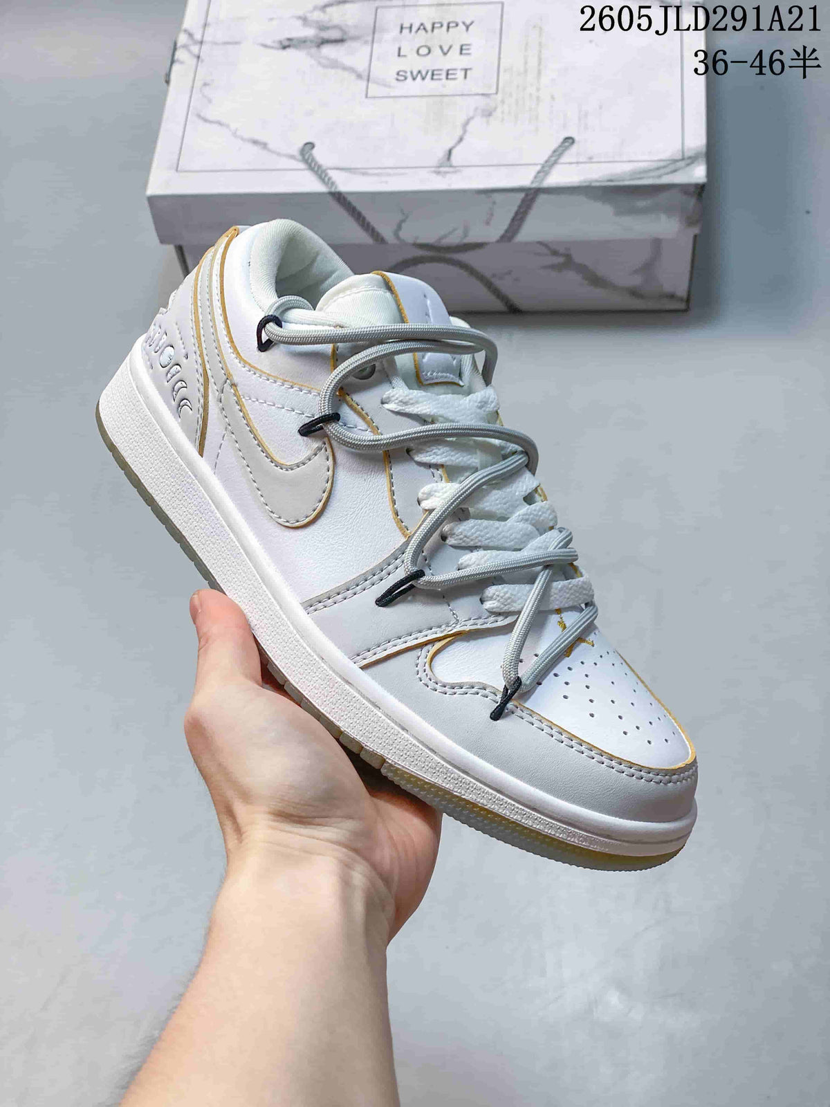 Angled view of the white and grey sneaker with gold-colored accents