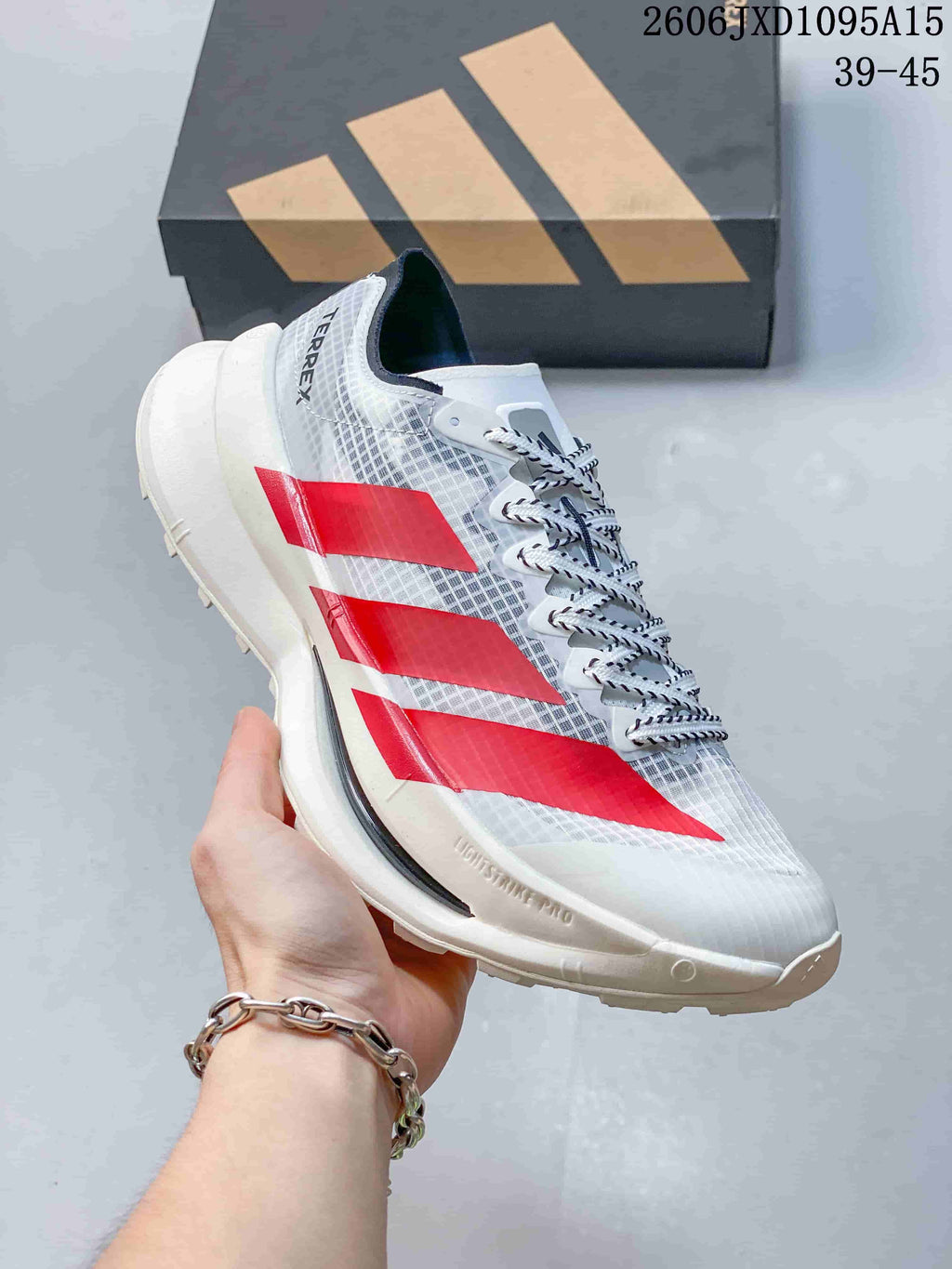 Side view of a white Adidas Terrex shoe with red stripes