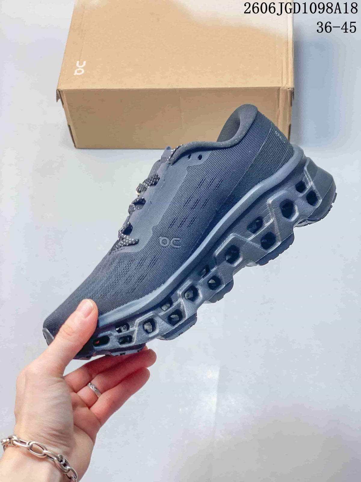 Side view of the charcoal-gray shoe and its geometric outsole.