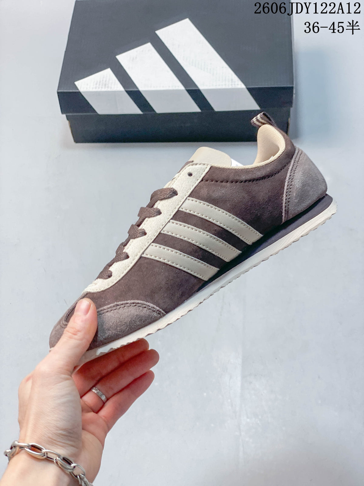 Side profile of a brown low-top sneaker with three cream-colored stripes