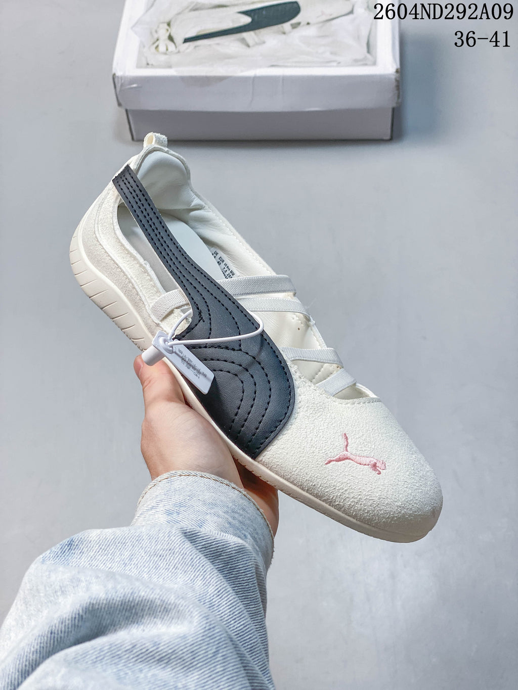Angled side view of the cream sneaker with navy stripe and pink Puma logo