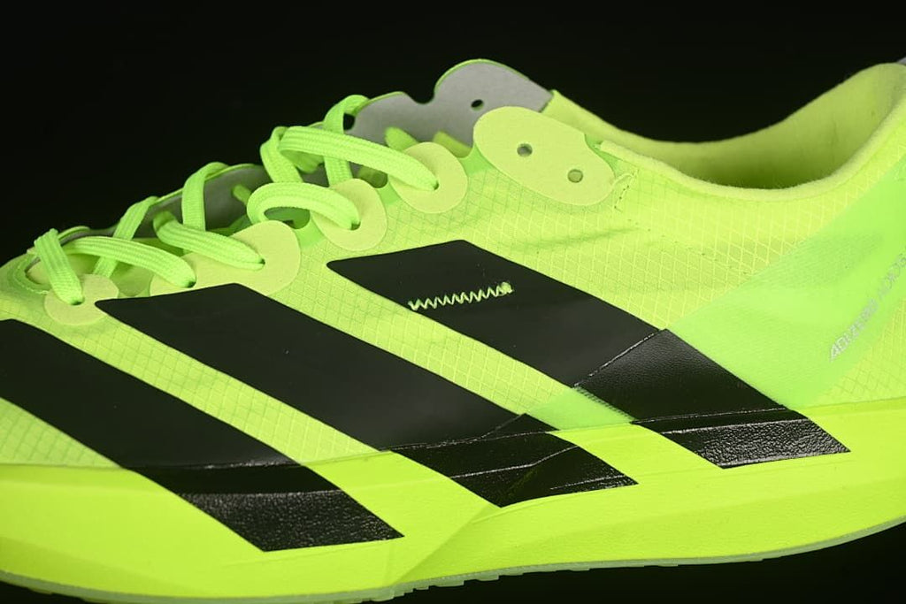 Close-up of the black side stripes, lace eyelets and neon upper