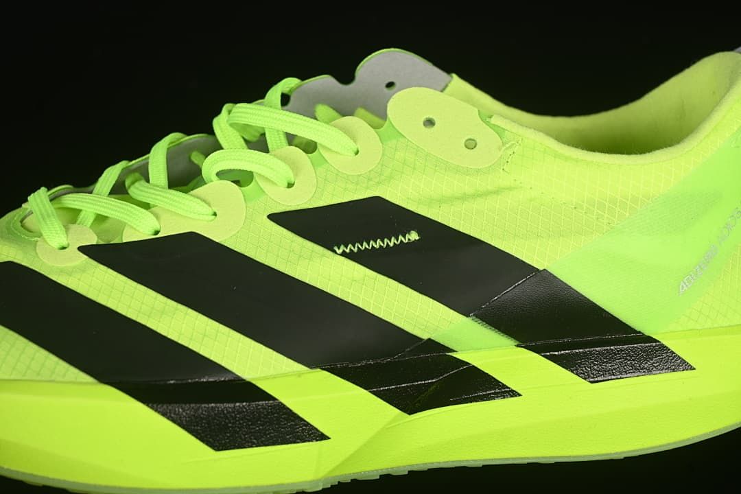 Close-up of the black side stripes, lace eyelets and neon upper