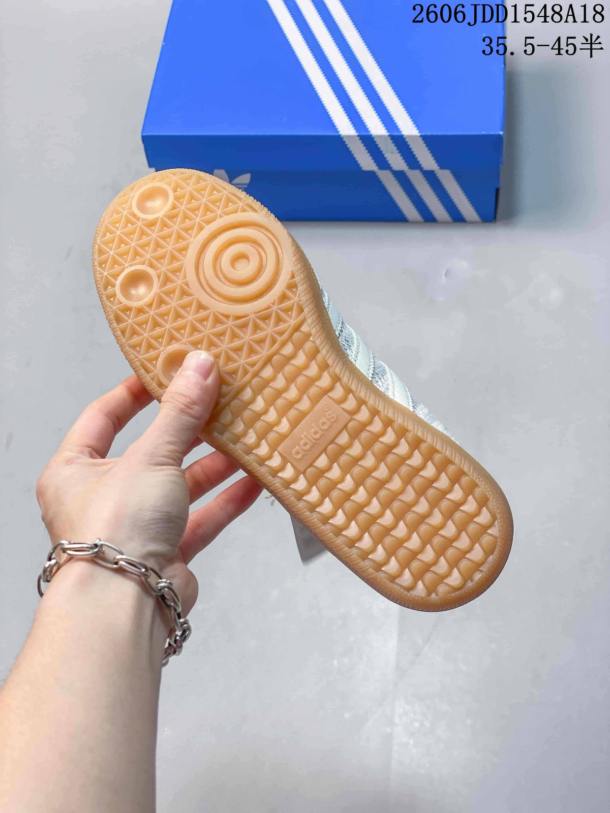 Underside of a sneaker showing a gum-colored outsole with patterned tread.