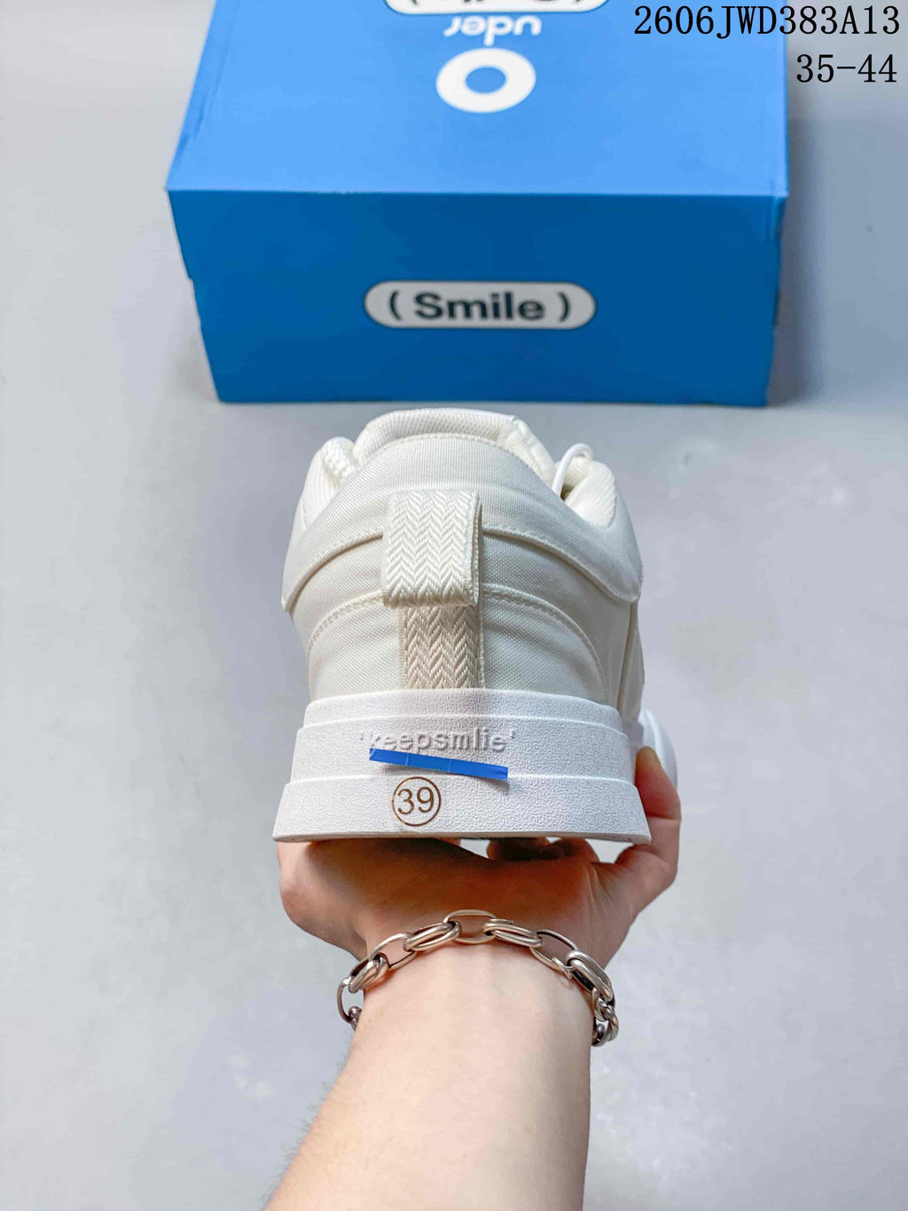 Rear view of the white sneaker with a size 39 marking on the sole