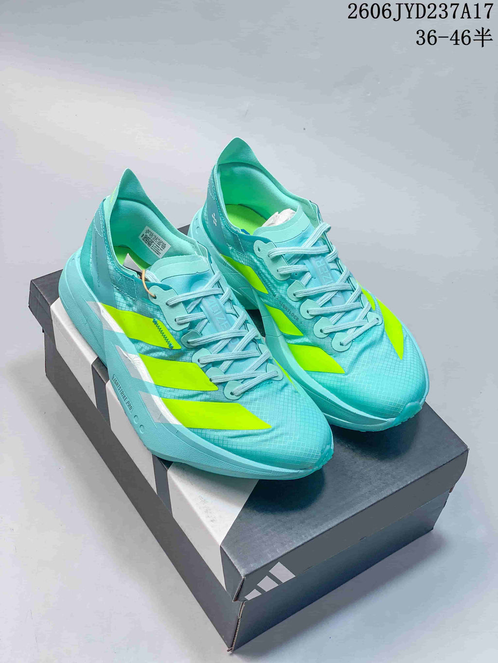 Pair of aqua Adidas Adizero Adios Pro 4 running shoes with neon yellow accents