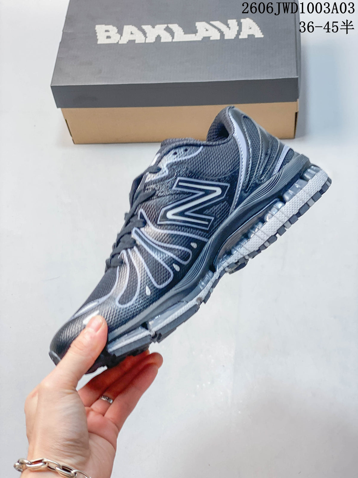 Side profile of the dark gray mesh-look sneaker with a large contrasting N logo.