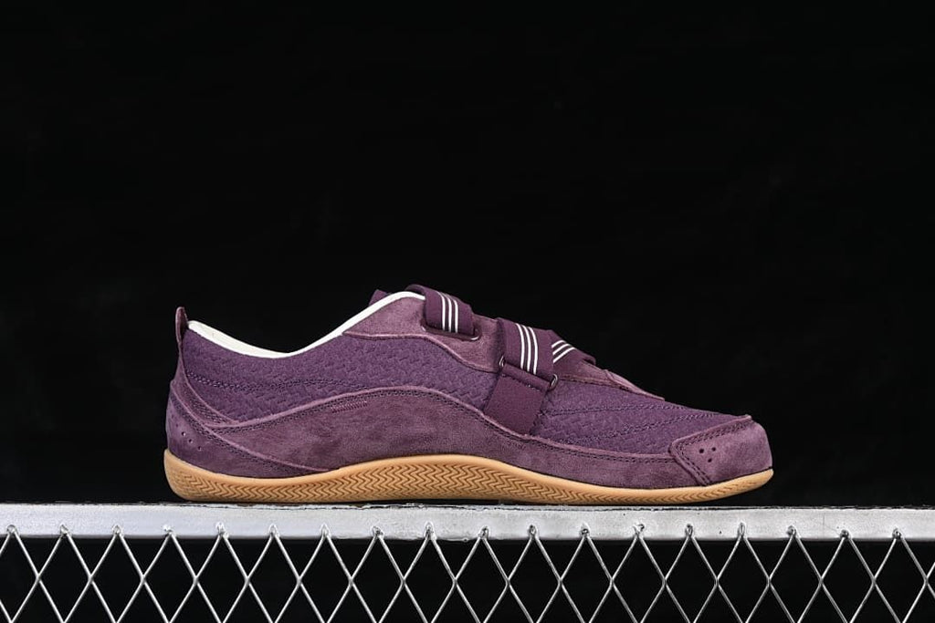 Side view of the purple sneaker showing its low-profile shape and straps