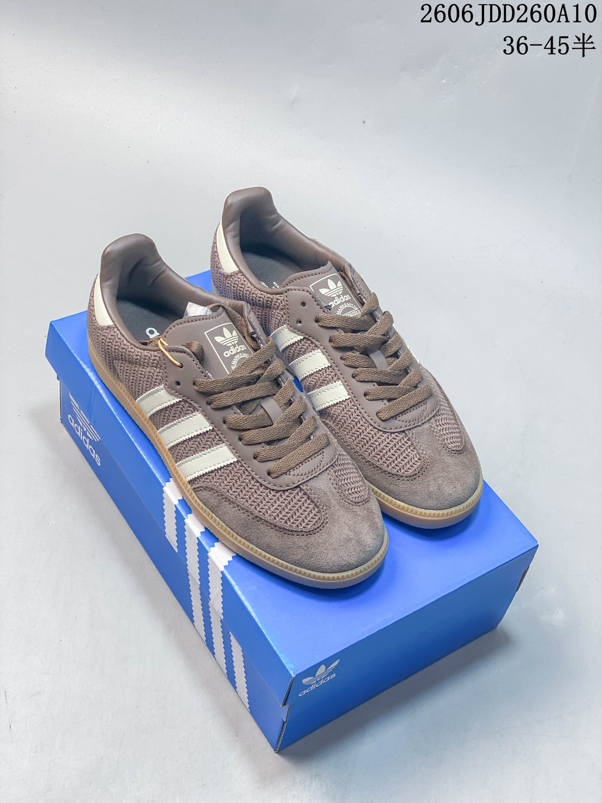 Pair of brown and off-white Samba OG sneakers shown on a blue box