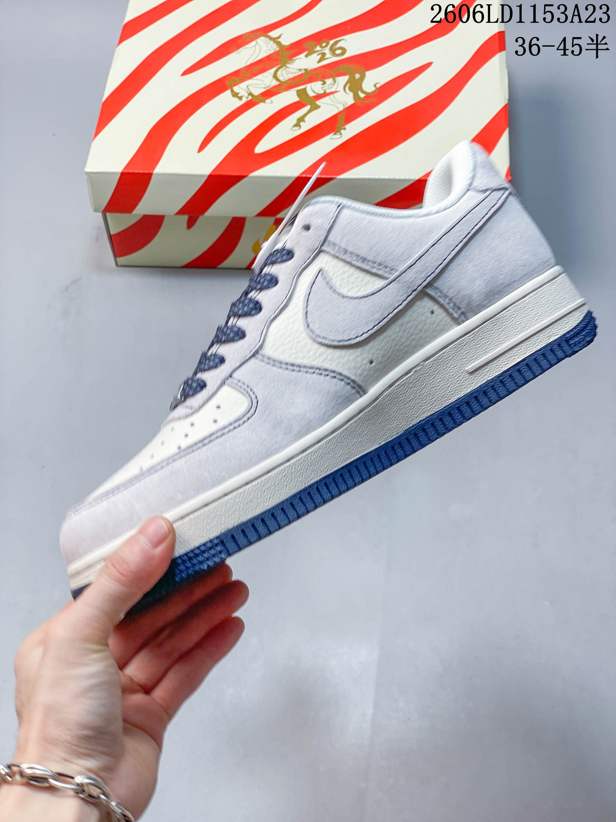 Side view of a white and pale gray Nike Air Force 1 '07 low-top sneaker with dark blue outsole accents