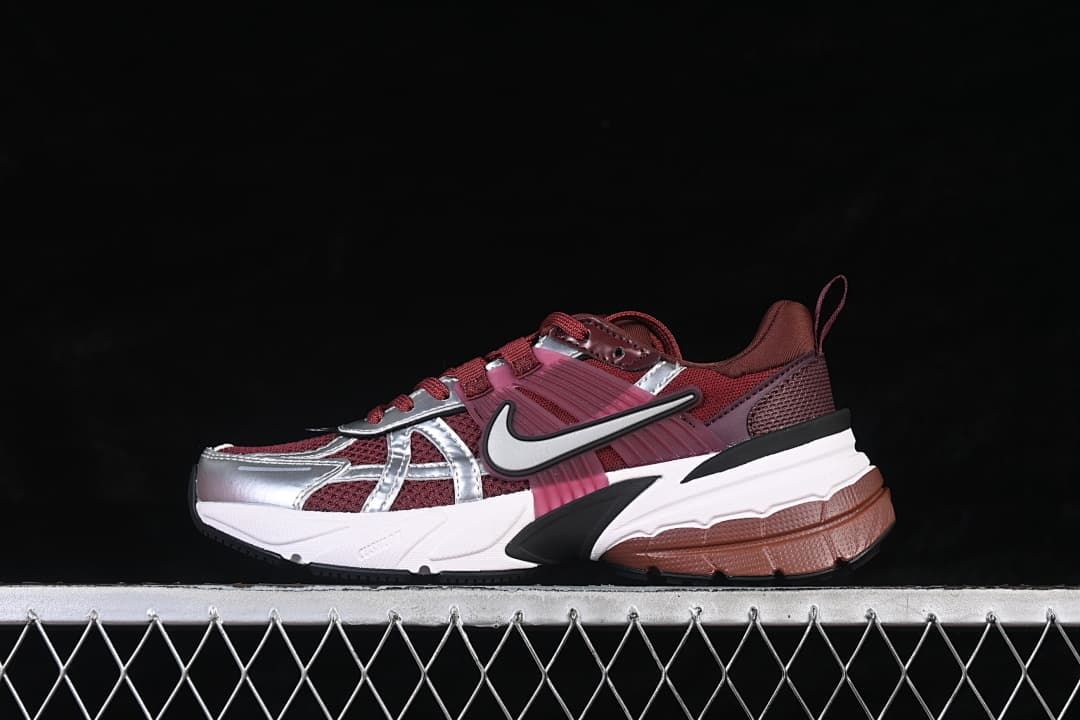 Side profile of burgundy Nike V2K Run sneakers with silver overlays and a layered sole