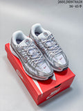 Pair of silver and white Nike Initiator running shoes displayed on a red box
