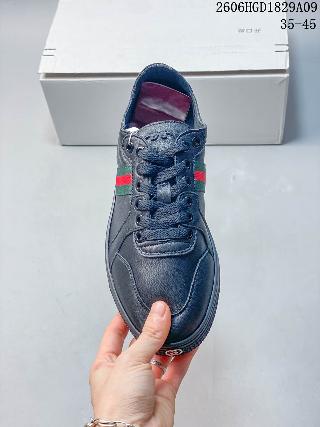 Front view of a dark navy lace-up sneaker with striped side details.