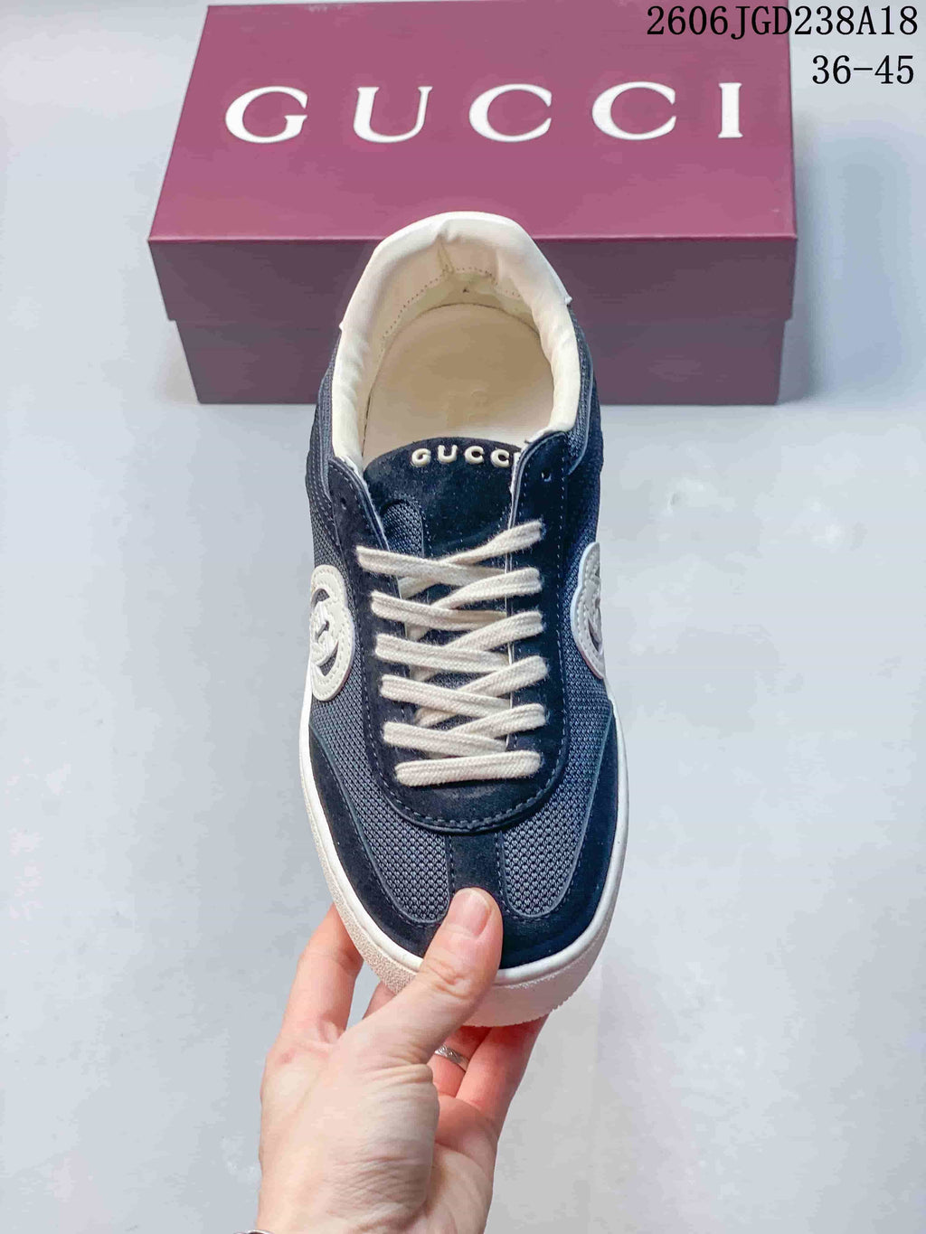 Front view of the lace-up sneaker with navy upper and white laces