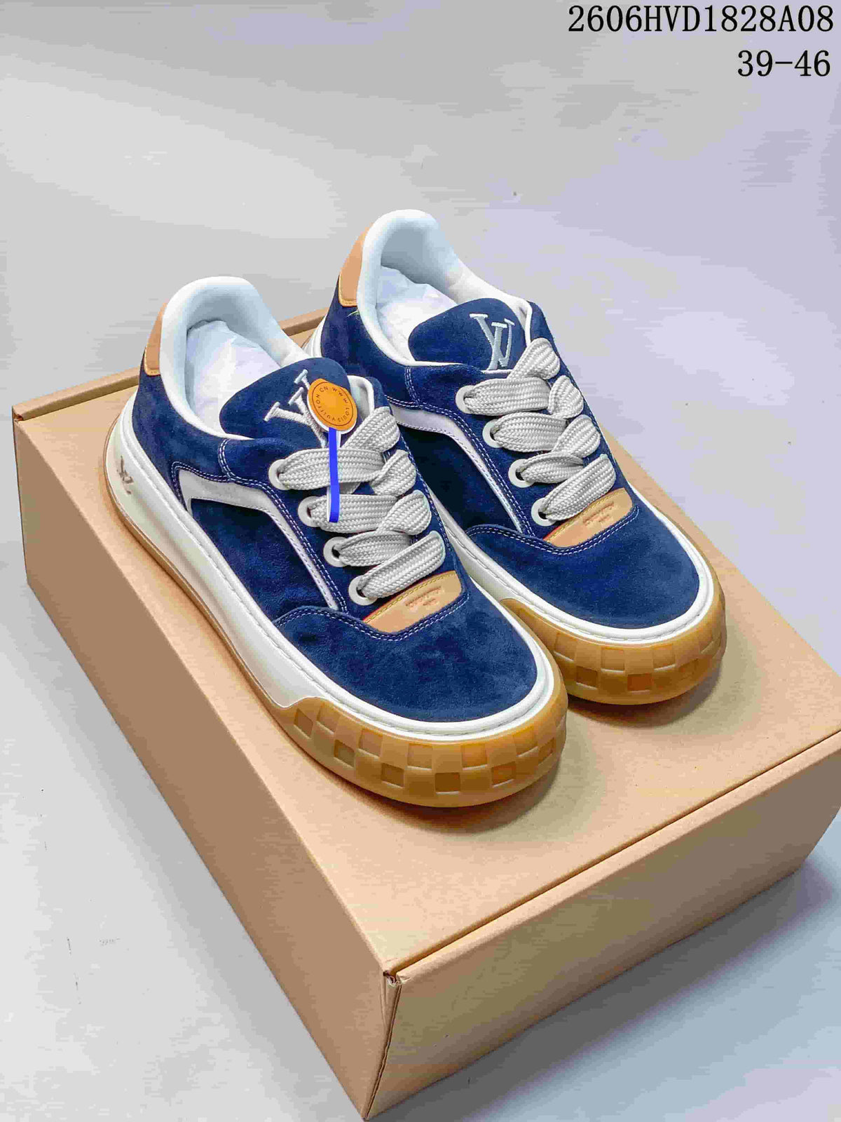 Pair of blue low-top sneakers with white laces, tan-colored details, and gum-colored outsoles