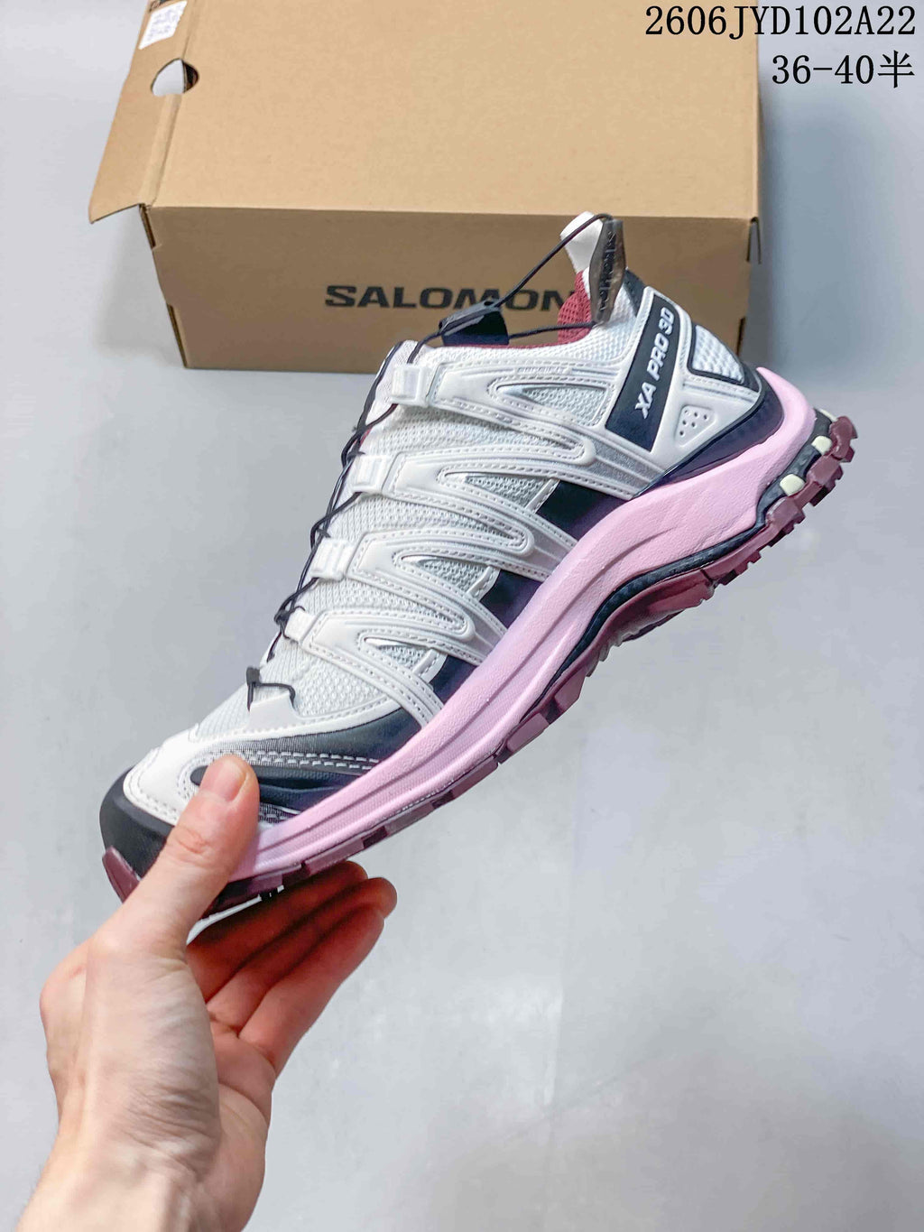Side view of a white Salomon XA Pro 3D shoe with a pink midsole and dark accents