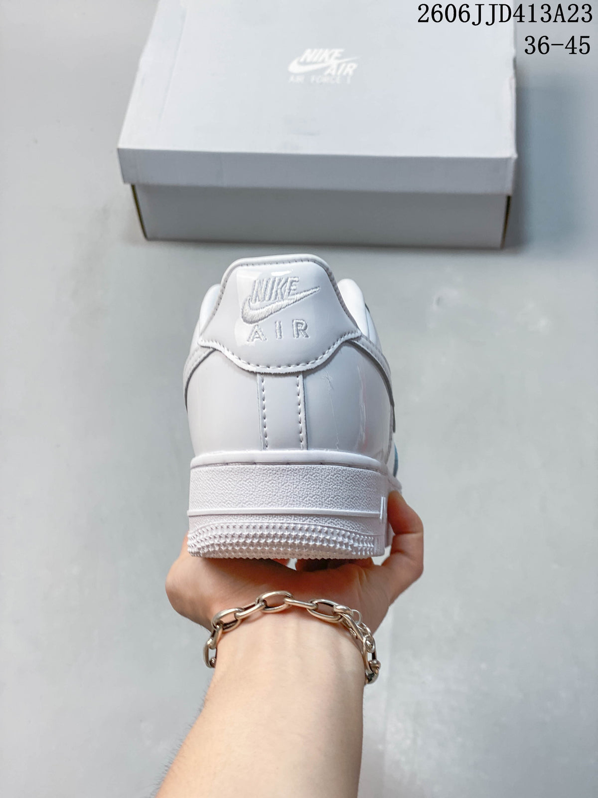 Rear view of the white sneaker showing heel branding and outsole