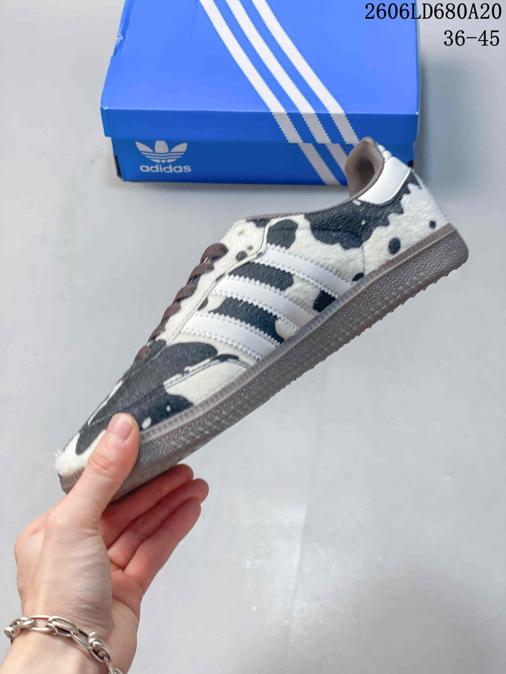 Side view showing the cow-print upper, three white stripes, and gum-colored outsole
