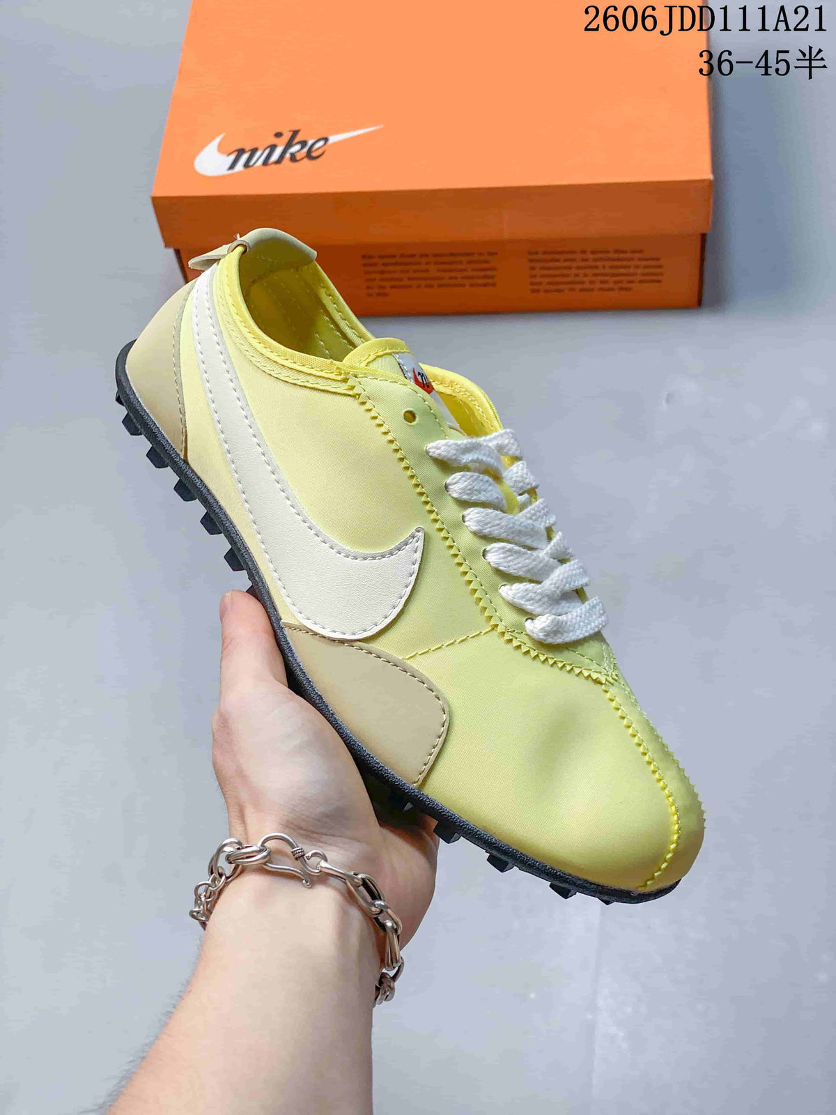 Angled side view of the pale yellow sneaker with white Swoosh accents and textured outsole.