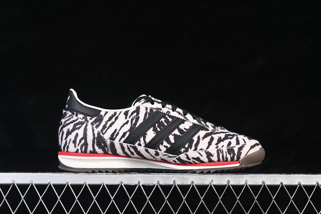 Side view of an adidas SL 72 OG sneaker with a black-and-cream animal-print upper and red midsole accent.