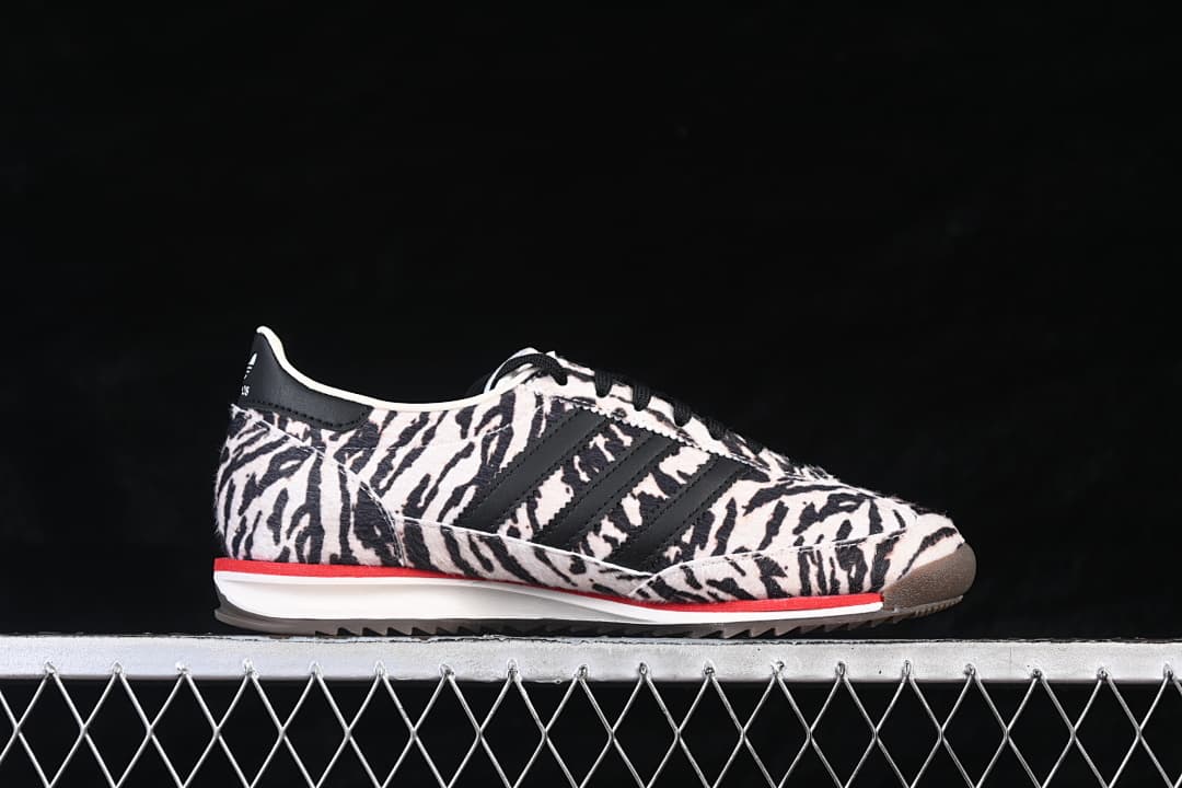 Side view of an adidas SL 72 OG sneaker with a black-and-cream animal-print upper and red midsole accent.