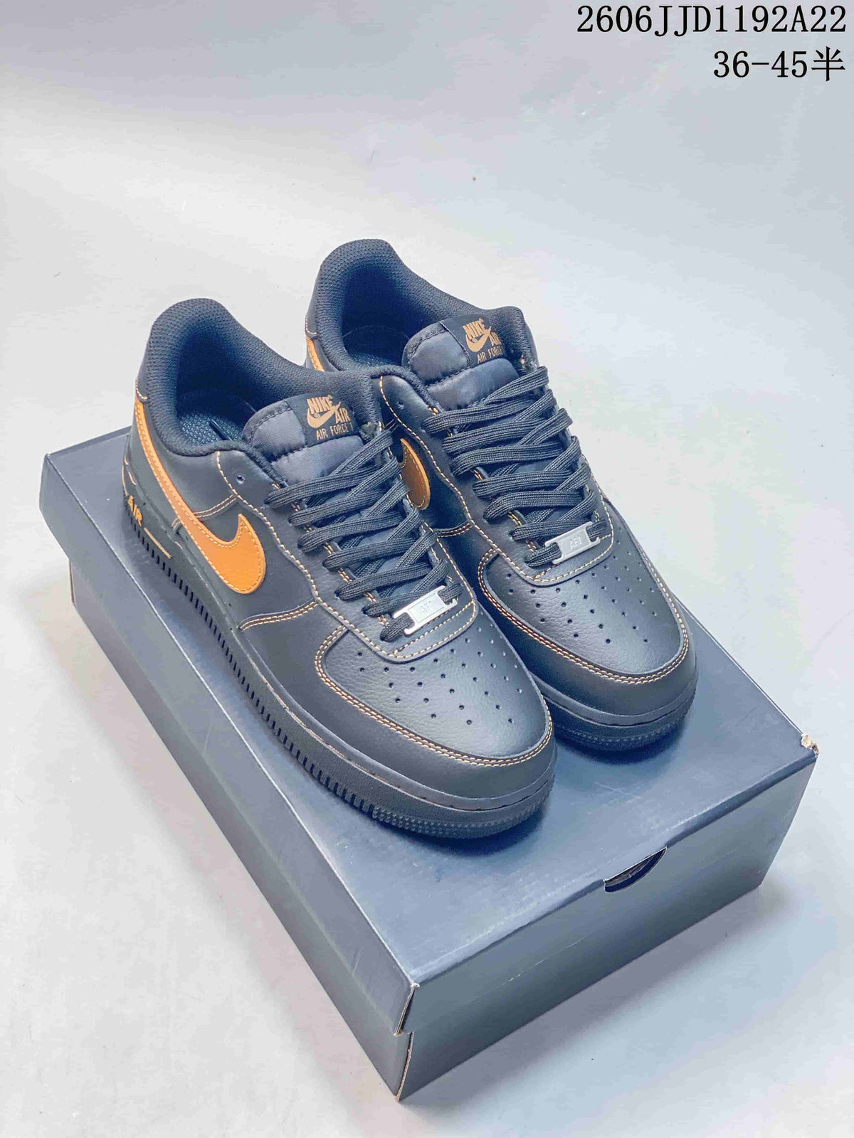 Charcoal gray low-top sneakers with orange swooshes and contrast stitching