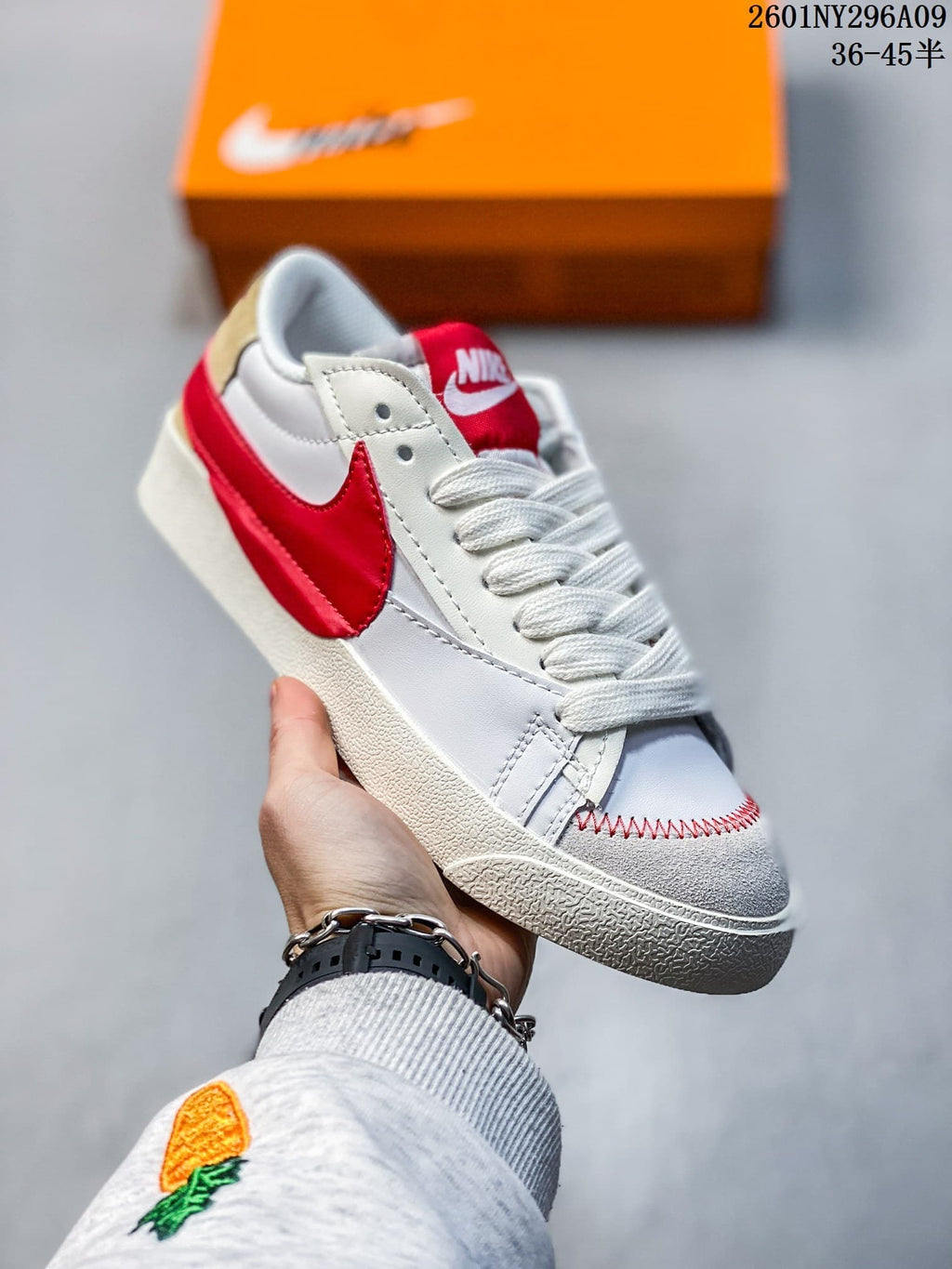 White Nike Blazer Low '77 Jumbo sneaker with a red Swoosh and red tongue.