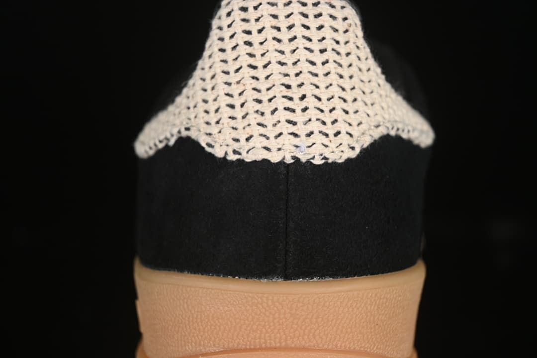 Close-up of the cream-colored textured heel detail on the black sneaker.