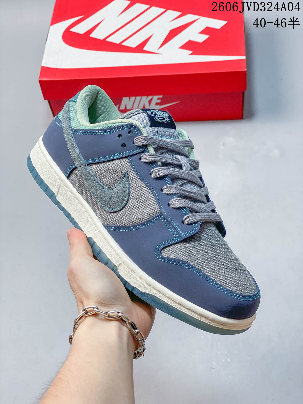 Angled side view of a gray and blue Nike Dunk Retro SE low-top sneaker